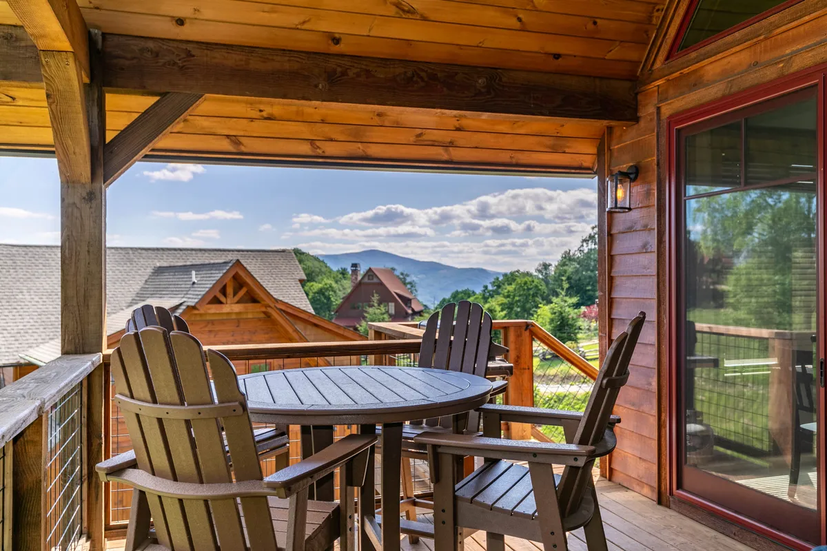 A wooden deck adorned with comfortable outdoor seating, offering panoramic mountain views. The deck is a peaceful spot for morning coffee or evening relaxation, surrounded by natural beauty.